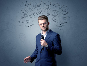 Businessman speaking into microphone with mixed doodles over his head